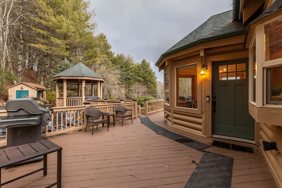 An inviting outdoor area with a gazebo, deck, barbecue grill, and comfortable seating. The scene captures the tranquil mood of relaxing or socializing outside, perfect for gatherings and mountain feasts.
