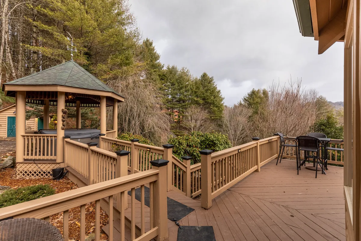 A welcoming gazebo and outdoor seating area are set on a deck with railing, all surrounded by serene greenery. The space invites guests to relax, socialize, or enjoy morning coffee while soaking in the natural atmosphere. Sunset vistas and the calming presence of the outdoors are evident.